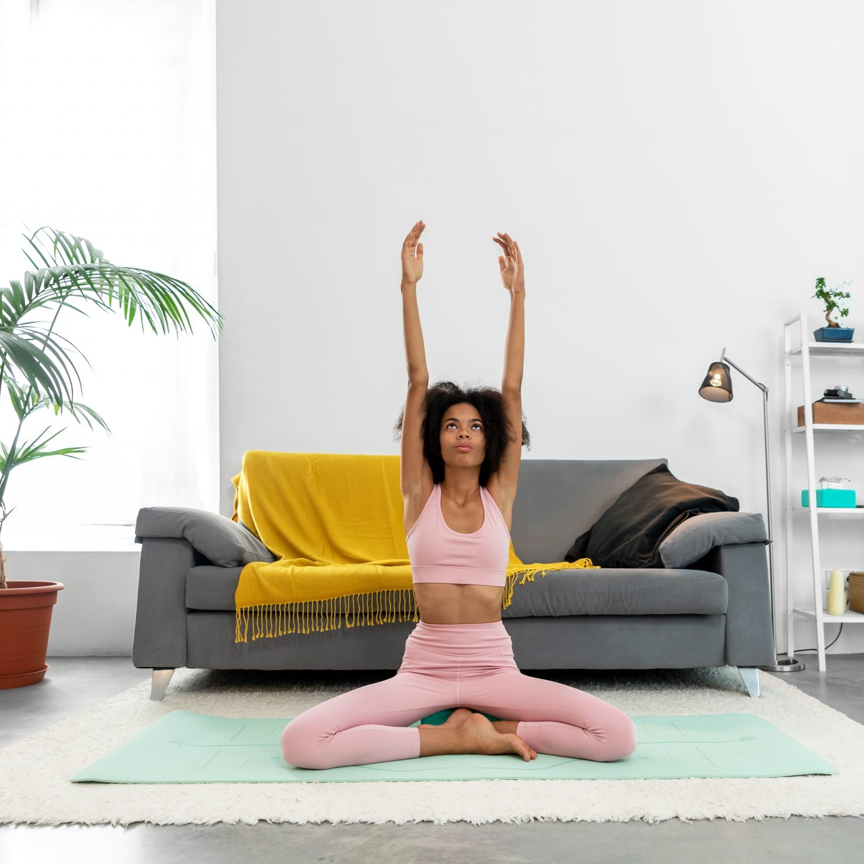 Afro woman practicing yoga at home
